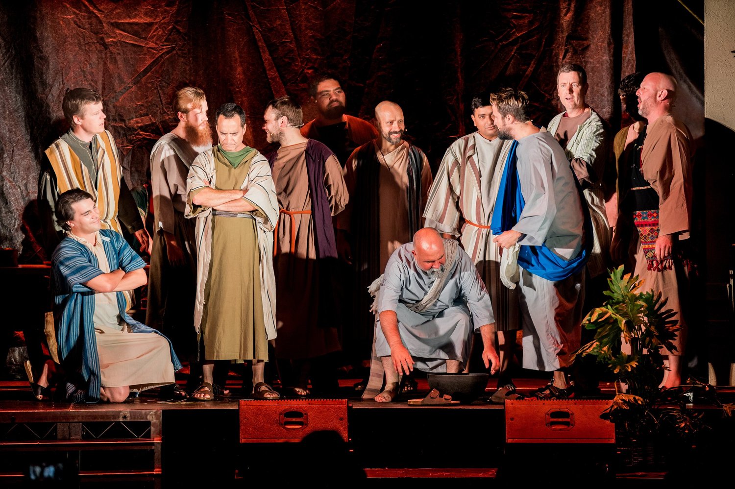 Jesus kneels to wash a disciple's feet while the company looks on